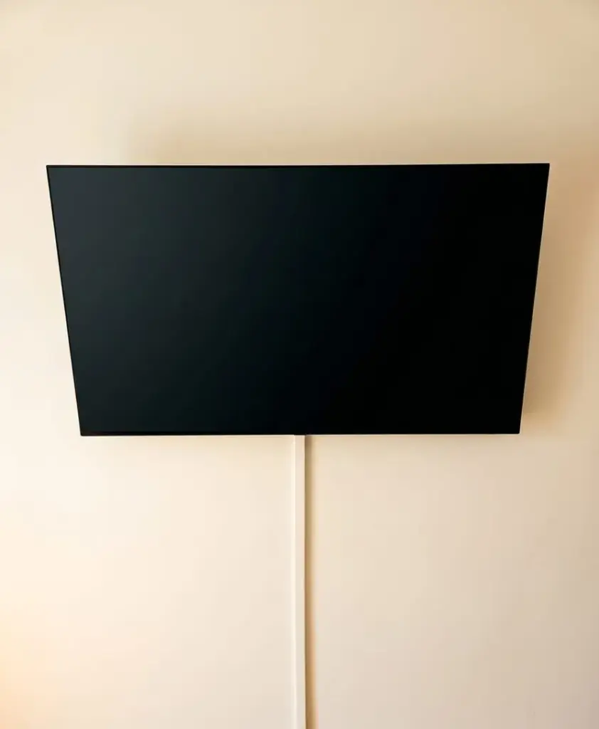 Flachbildfernseher an der Wand montiert, Kabel verdeckt in einem weißen Kabelkanal